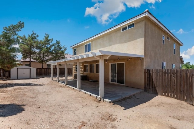 14075 Tourmaline St, Hesperia, CA 92344 - back of house featuring stucco siding, a storage unit, a patio, a fenced backyard, and a pergola