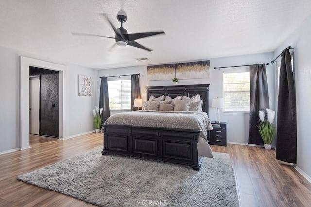 14075 Tourmaline St, Hesperia, CA 92344 - bedroom with multiple windows, wood finished floors, a textured ceiling, and ceiling fan