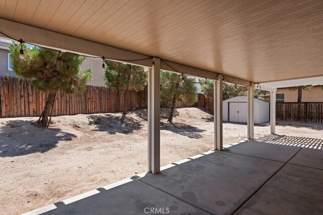14075 Tourmaline St, Hesperia, CA 92344 - fenced backyard featuring a patio area and a storage shed