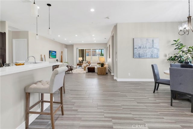 6908 Oleander Ave, Fontana, CA 92336 - kitchen featuring recessed lighting, open floor plan, light wood-style floors, and pendant lighting