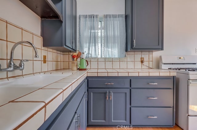 2741 S Walker Ave, San Pedro, CA 90731 - kitchen with white gas stove, tasteful backsplash, and tile countertops