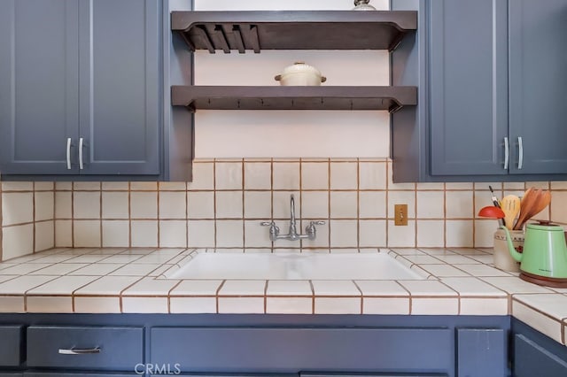 2741 S Walker Ave, San Pedro, CA 90731 - kitchen featuring blue cabinetry, tile counters, backsplash, and open shelves