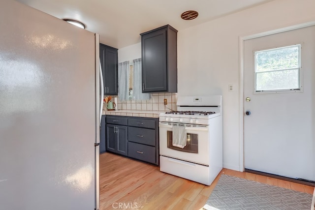 2741 S Walker Ave, San Pedro, CA 90731 - kitchen featuring freestanding refrigerator, white range with gas stovetop, light wood-type flooring, decorative backsplash, and gray cabinets