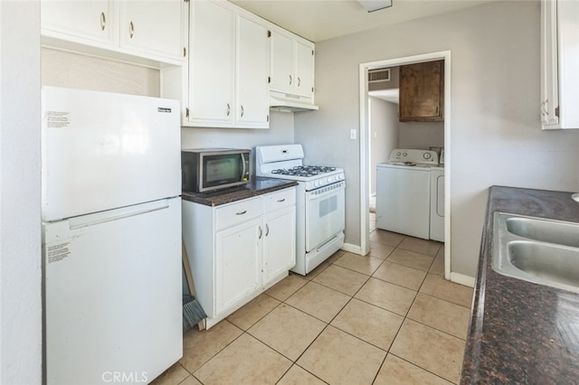 15917 Lee St, Mojave, CA 93501 - kitchen with white appliances, under cabinet range hood, white cabinets, light tile patterned floors, and washer and dryer
