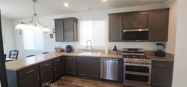 315 Fuente Dr, Guadalupe, CA 93434 - kitchen with stainless steel appliances, dark brown cabinetry, a peninsula, light stone counters, and dark wood-style flooring