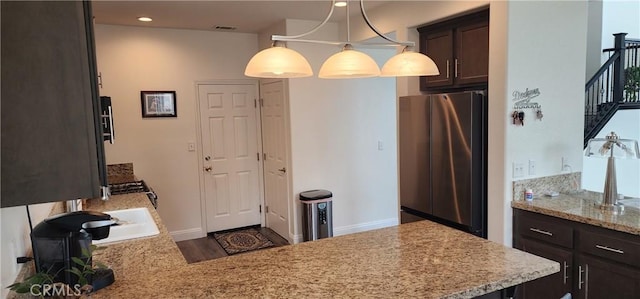 315 Fuente Dr, Guadalupe, CA 93434 - kitchen featuring freestanding refrigerator, dark brown cabinets, light stone counters, wood finished floors, and recessed lighting