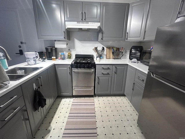3029 Broadway Unit 22, San Diego, CA 92102 - kitchen with stainless steel appliances, under cabinet range hood, gray cabinetry, and light flooring
