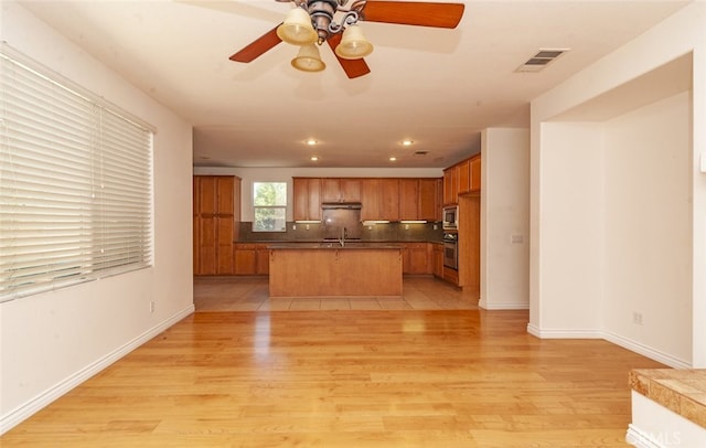 26508 Veramonte Ave, Murrieta, CA 92562 - kitchen with stainless steel appliances, ceiling fan, light wood-style flooring, open floor plan, and tasteful backsplash