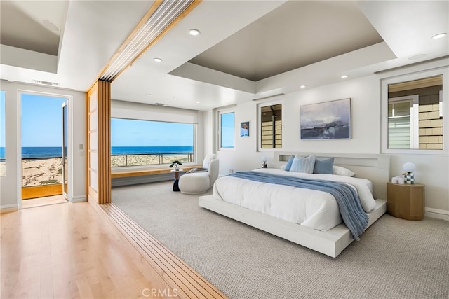 1554 E Oceanfront, Newport Beach, CA 92661 - bedroom with a tray ceiling, a water view, recessed lighting, and wood finished floors