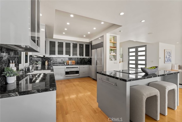 1554 E Oceanfront, Newport Beach, CA 92661 - kitchen featuring high quality fridge, oven, tasteful backsplash, recessed lighting, and glass insert cabinets