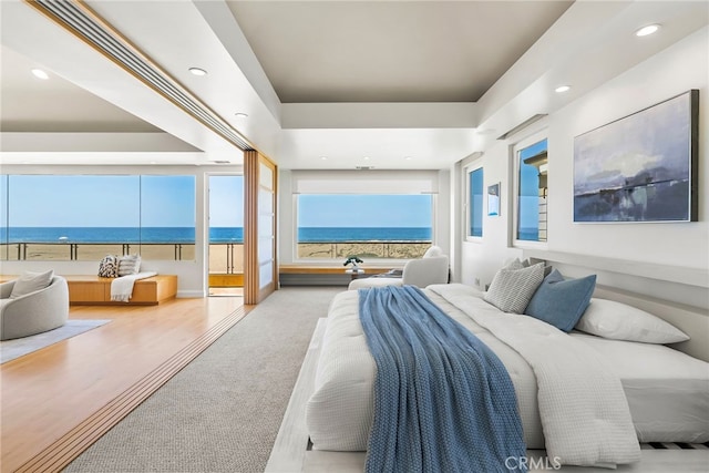 1554 E Oceanfront, Newport Beach, CA 92661 - bedroom with a water view, recessed lighting, access to outside, wood finished floors, and a tray ceiling