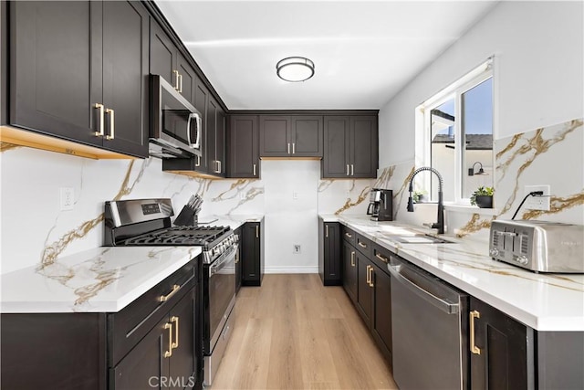 5001 N Darfield Ave, Covina, CA 91724 - kitchen featuring appliances with stainless steel finishes, light wood-type flooring, tasteful backsplash, and light stone counters