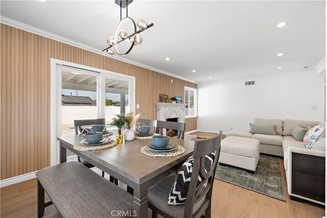 5001 N Darfield Ave, Covina, CA 91724 - dining space with crown molding, light wood finished floors, a high end fireplace, a chandelier, and recessed lighting