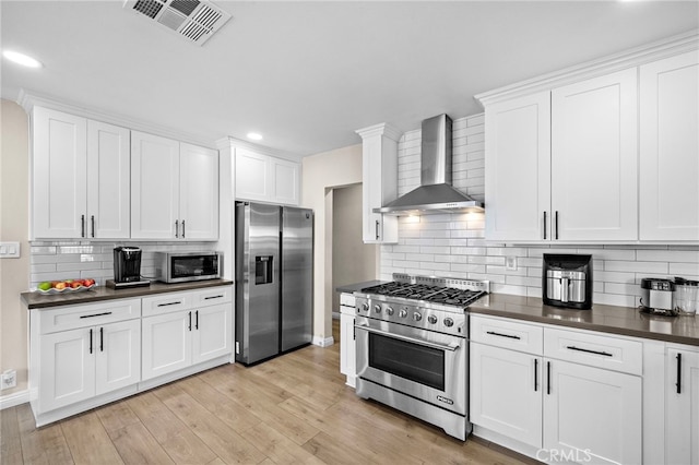 2729 Fairman St, Lakewood, CA 90712 - kitchen with appliances with stainless steel finishes, wall chimney exhaust hood, dark countertops, backsplash, and recessed lighting