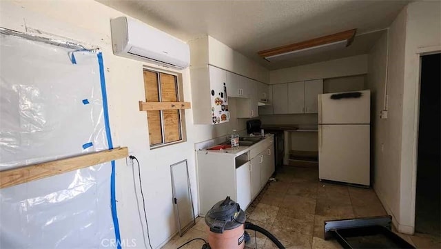 15236 Painted Hills Rd, Whitewater, CA 92282 - kitchen with freestanding refrigerator, a wall mounted AC, and white cabinets