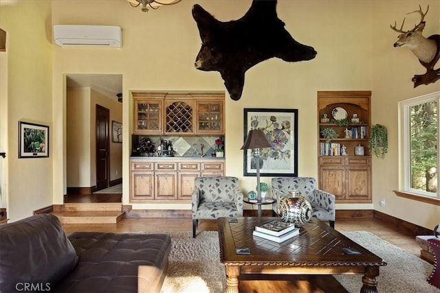 207 N Fairway Dr N, Lake Arrowhead, CA 92391 - living room with a wall mounted AC, a high ceiling, wood finished floors, and a dry bar