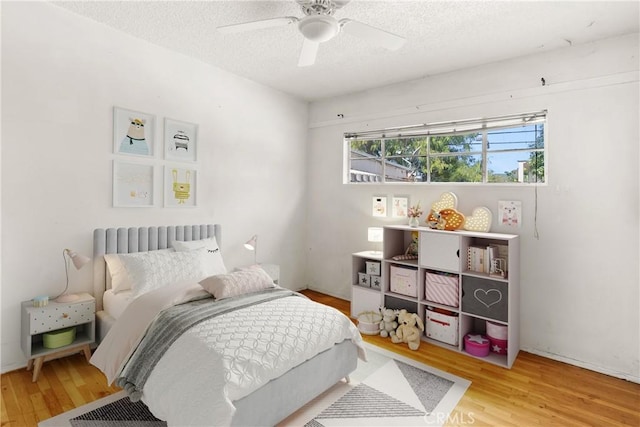 1450 Pepper Tree Ln, San Bernardino, CA 92404 - bedroom with light wood-style flooring, a textured ceiling, and a ceiling fan