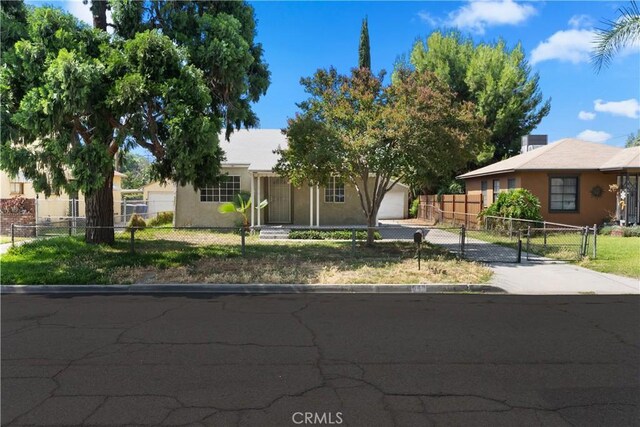 549 E Evans St, San Bernardino, CA 92404 - view of front of property with a fenced front yard, driveway, stucco siding, and a garage