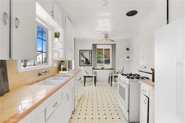549 E Evans St, San Bernardino, CA 92404 - kitchen with white appliances, tile counters, healthy amount of natural light, and white cabinets