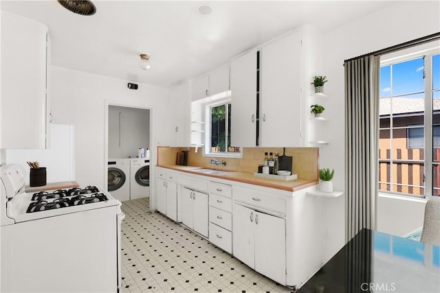 549 E Evans St, San Bernardino, CA 92404 - kitchen with white gas range oven, washer and clothes dryer, light countertops, white cabinets, and decorative backsplash