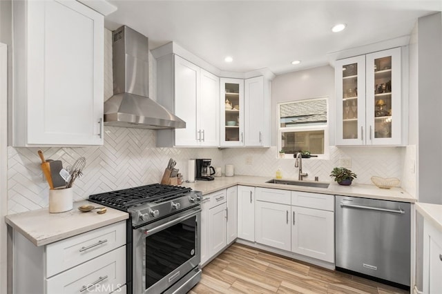 1434 N Rose St, Burbank, CA 91505 - kitchen with stainless steel appliances, wall chimney exhaust hood, tasteful backsplash, white cabinetry, and light wood-style floors