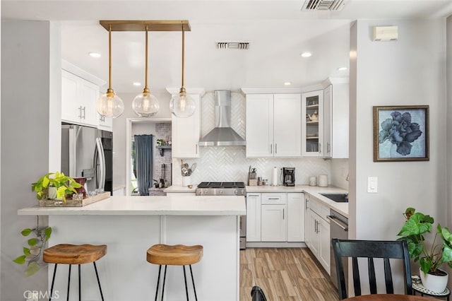 1434 N Rose St, Burbank, CA 91505 - kitchen featuring wall chimney range hood, appliances with stainless steel finishes, a peninsula, a kitchen breakfast bar, and backsplash