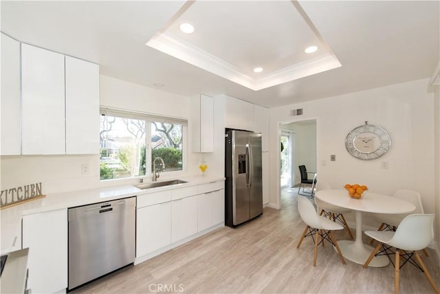 10 Windsong, Irvine, CA 92614 - kitchen featuring appliances with stainless steel finishes, light countertops, white cabinets, recessed lighting, and ornamental molding