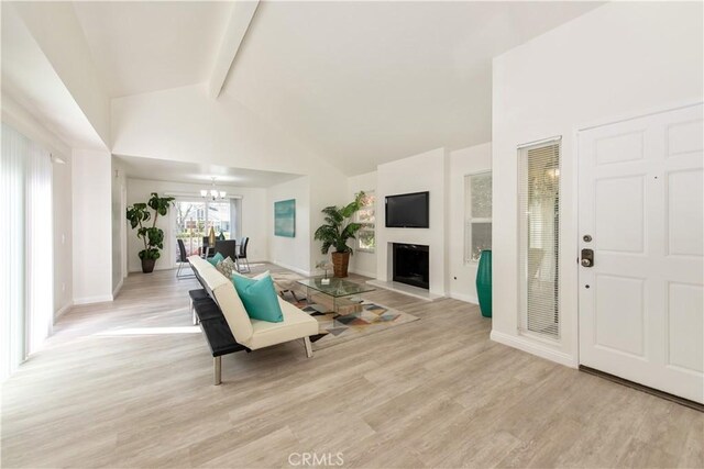 10 Windsong, Irvine, CA 92614 - living room with beamed ceiling, high vaulted ceiling, a chandelier, light wood-type flooring, and a fireplace with raised hearth