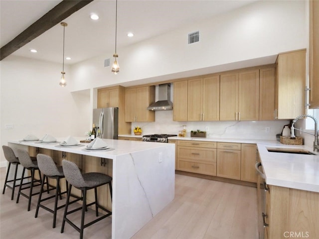 3518 W 228th St, Torrance, CA 90505 - kitchen with wall chimney exhaust hood, stainless steel appliances, light brown cabinets, light countertops, and light wood finished floors