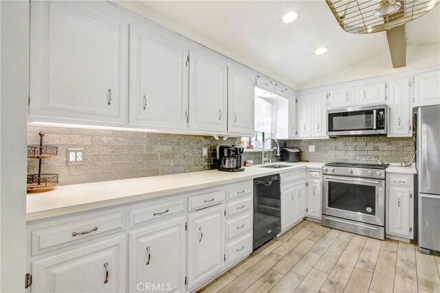 467 W Casad St, Covina, CA 91723 - kitchen with stainless steel appliances, white cabinetry, decorative backsplash, lofted ceiling, and recessed lighting