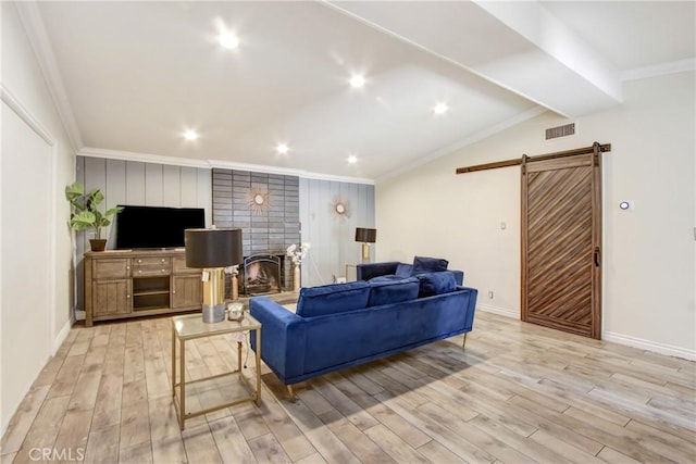 467 W Casad St, Covina, CA 91723 - living room featuring a barn door, light wood-type flooring, ornamental molding, recessed lighting, and a brick fireplace