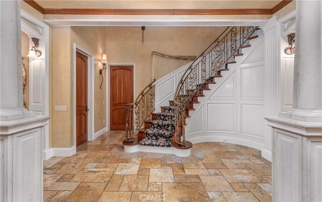919 S Gretna Green Way, Los Angeles, CA 90049 - stairway with stone tile floors, a decorative wall, and decorative columns