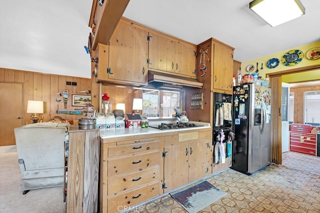 15043 Tuba St, San Fernando, CA 91345 - kitchen with black appliances, under cabinet range hood, light countertops, and wooden walls