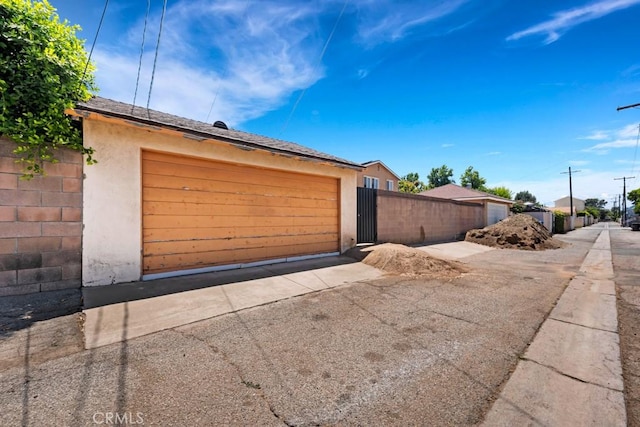 15043 Tuba St, San Fernando, CA 91345 - view of side of home with stucco siding, a gate, and asphalt driveway