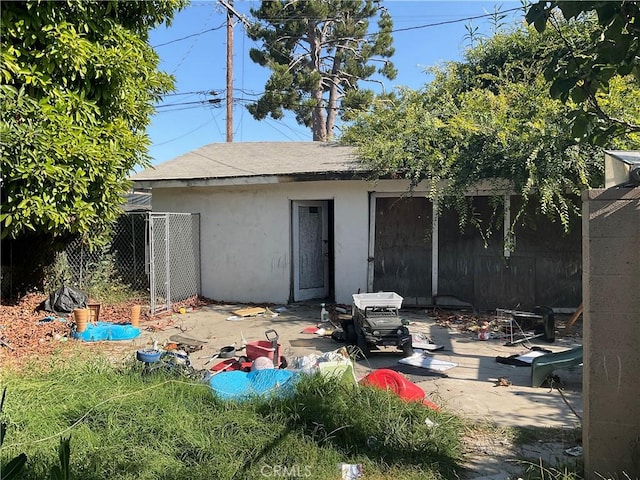 1330 E 56th St, Long Beach, CA 90805 - back of property with stucco siding, a shingled roof, and a patio