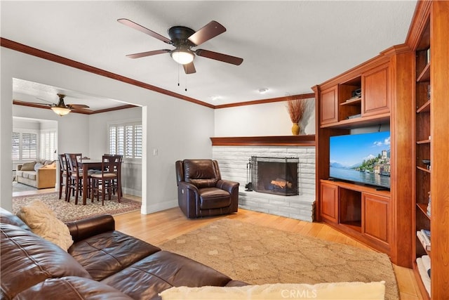 1225 Carlsbad St, Placentia, CA 92870 - living room with a ceiling fan, a fireplace with raised hearth, light wood-style flooring, and crown molding
