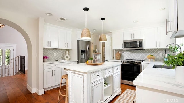 23782 Lagarto, Mission Viejo, CA 92691 - kitchen featuring appliances with stainless steel finishes, arched walkways, a center island, white cabinetry, and recessed lighting