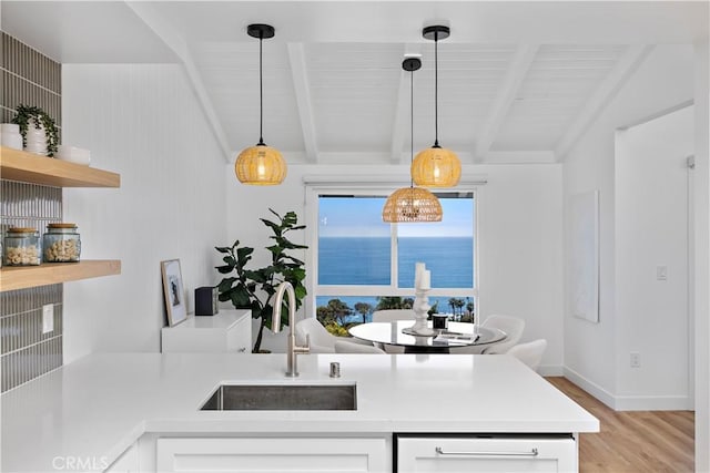 21659 Ocean Vista Dr Unit 20, Laguna Beach, CA 92651 - kitchen with light wood-style flooring, light countertops, white cabinetry, and decorative light fixtures