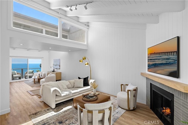 21659 Ocean Vista Dr Unit 20, Laguna Beach, CA 92651 - living area with a fireplace, wood finished floors, beamed ceiling, a towering ceiling, and a water view