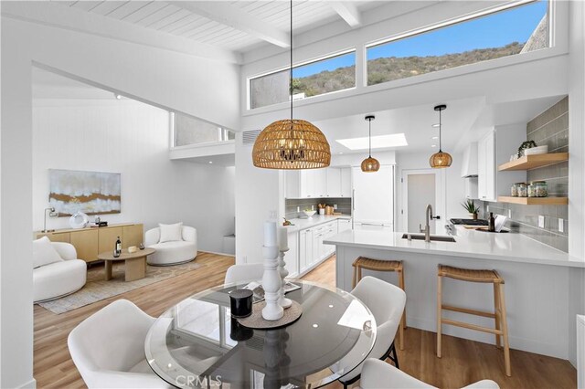 21659 Ocean Vista Dr Unit 20, Laguna Beach, CA 92651 - dining room with light wood-style flooring, beam ceiling, and a high ceiling