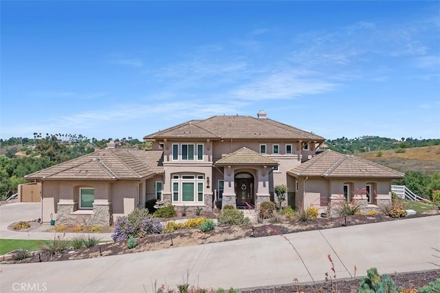 2841 Dos Lomas Pl, Fallbrook, CA 92028 - view of front facade featuring stucco siding, stone siding, a tiled roof, and driveway