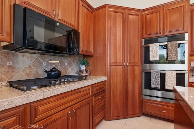 2841 Dos Lomas Pl, Fallbrook, CA 92028 - kitchen with appliances with stainless steel finishes, brown cabinetry, tasteful backsplash, and light tile patterned floors