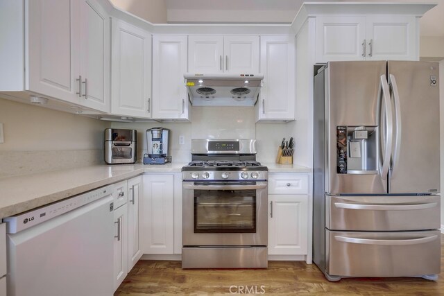 13418 Palm Pl, Cerritos, CA 90703 - kitchen featuring stainless steel appliances, exhaust hood, white cabinets, and light countertops
