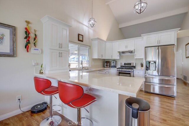 13418 Palm Pl, Cerritos, CA 90703 - kitchen with stainless steel appliances, a breakfast bar, white cabinetry, and high vaulted ceiling