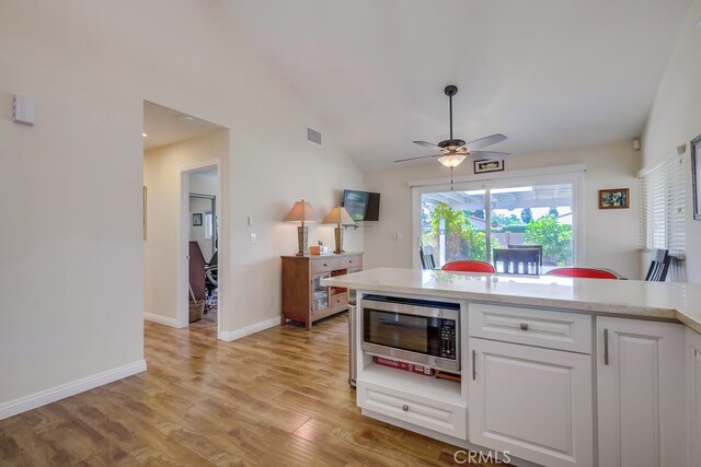 13418 Palm Pl, Cerritos, CA 90703 - kitchen featuring stainless steel microwave, ceiling fan, light countertops, white cabinetry, and light wood-style flooring