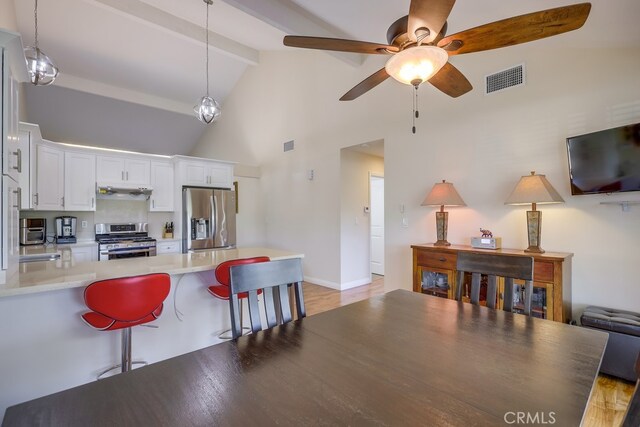 13418 Palm Pl, Cerritos, CA 90703 - kitchen with stainless steel appliances, a peninsula, beam ceiling, white cabinetry, and ceiling fan