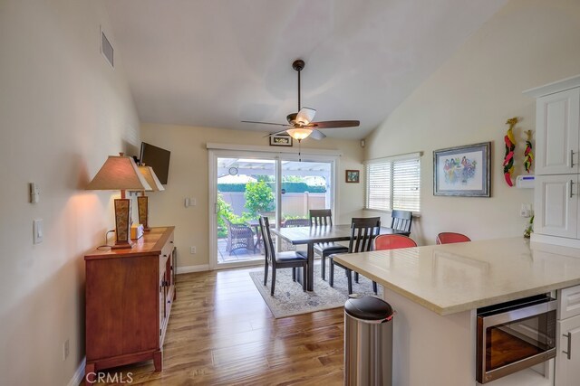 13418 Palm Pl, Cerritos, CA 90703 - dining space with vaulted ceiling, a ceiling fan, and wood finished floors
