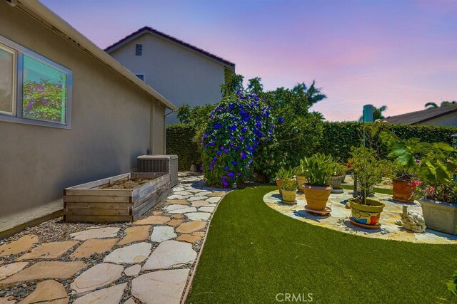 13418 Palm Pl, Cerritos, CA 90703 - yard at dusk featuring a vegetable garden and a yard
