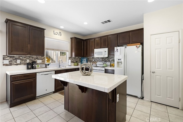 544 W Elm Park Ave, Rialto, CA 92376 - kitchen featuring white appliances, tile countertops, dark brown cabinetry, light tile patterned floors, and recessed lighting