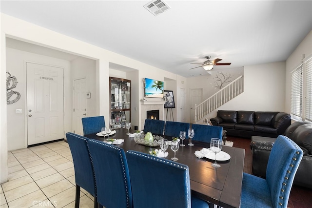 544 W Elm Park Ave, Rialto, CA 92376 - dining room featuring stairway, a ceiling fan, a tile fireplace, and light tile patterned floors